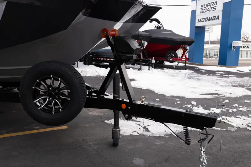 Slide: The Image of 2026 MasterCraft XT22 boat trailer with snow-covered ground at dealership. - 12