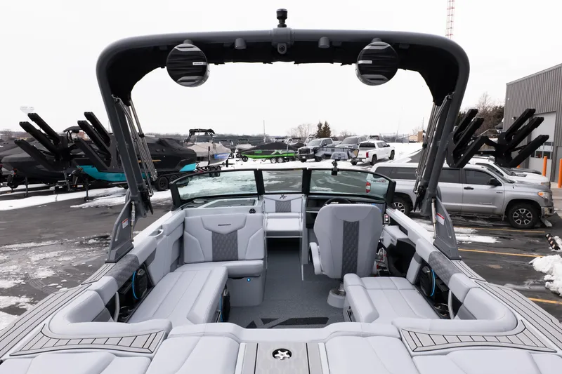 Slide: The Image of 2026 MasterCraft XT22 boat interior with sleek seating and modern design in a snowy outdoor setting. - 13