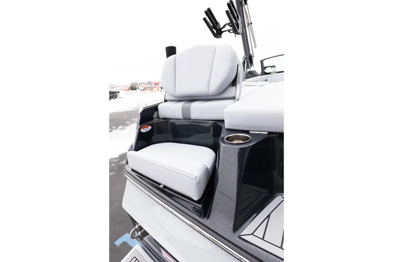 Slide: The Image of 2026 MasterCraft XT22 boat with sleek seating and cup holder, showcased in snowy setting. - 19