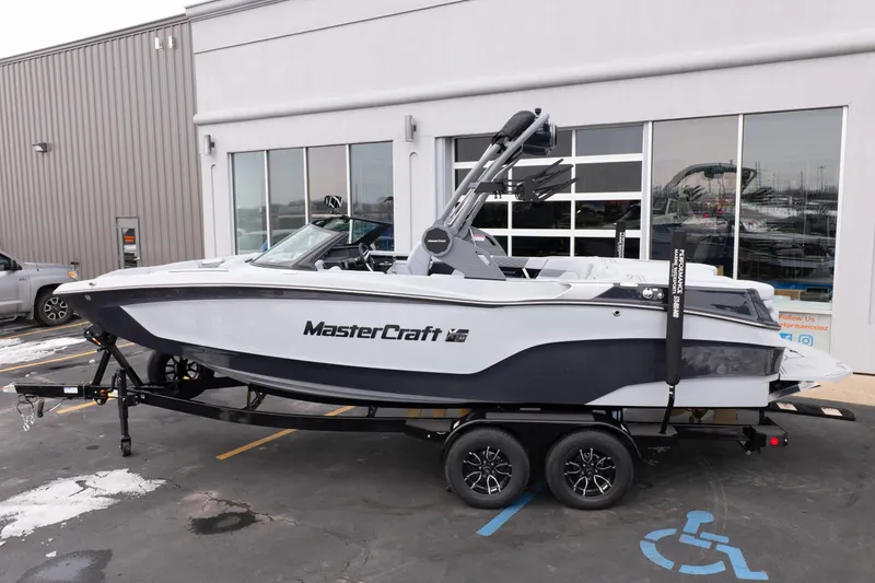 Slide: The Image of 2026 MasterCraft XT22 boat on trailer outside dealership. - 3