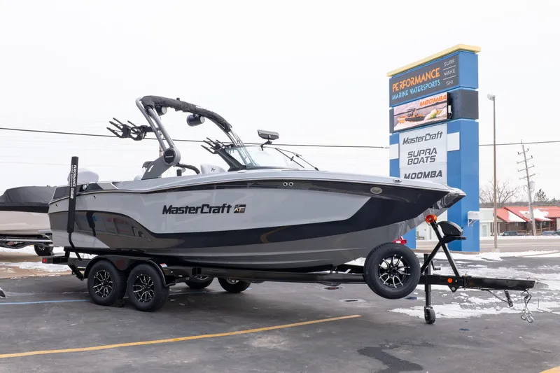 Slide: The Image of 2026 MasterCraft XT22 boat on trailer at dealership, winter setting. - 8