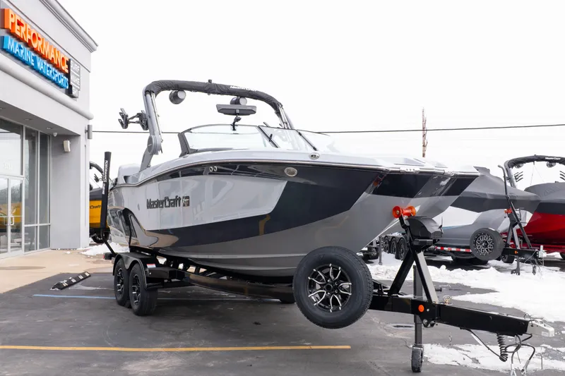 Slide: The Image of 2026 MasterCraft XT22 boat on trailer at Performance Marine Watersports dealership. - 9