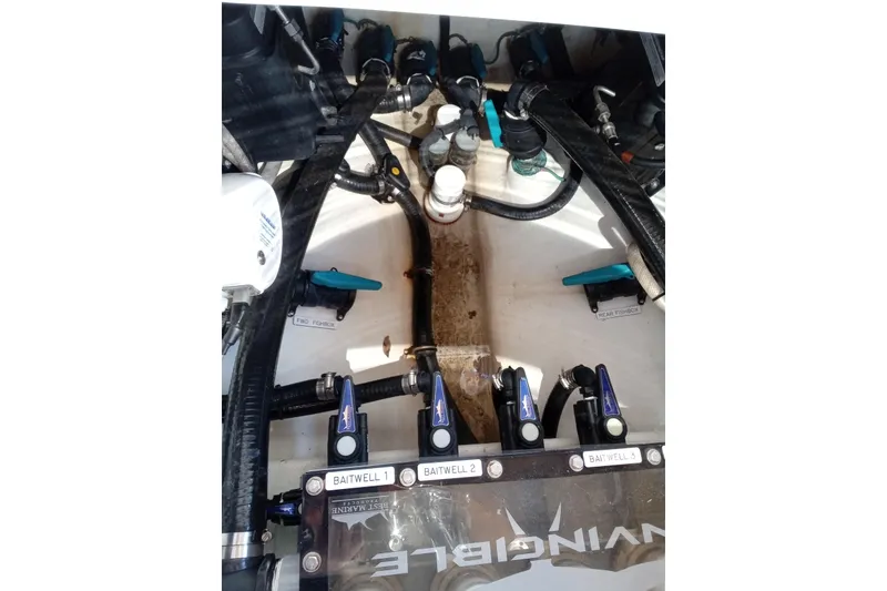 Slide: The Image of Engine compartment of 2022 Invincible 39 Open Fisherman with baitwell controls and hoses. - 11