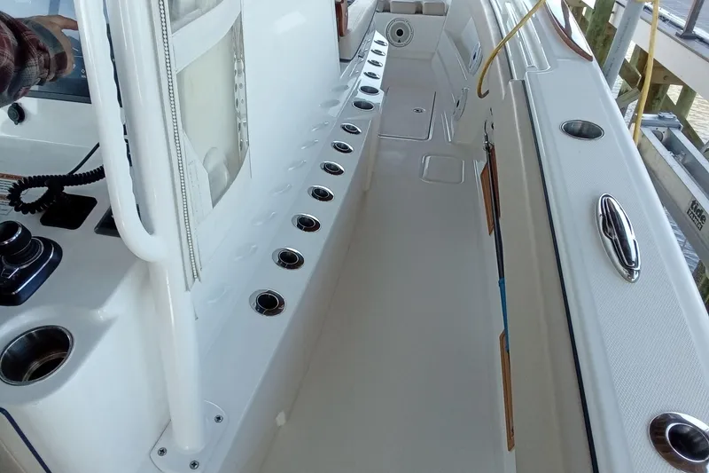 Slide: The Image of 2022 Invincible 39 Open Fisherman boat interior with rod holders and control panel. - 19