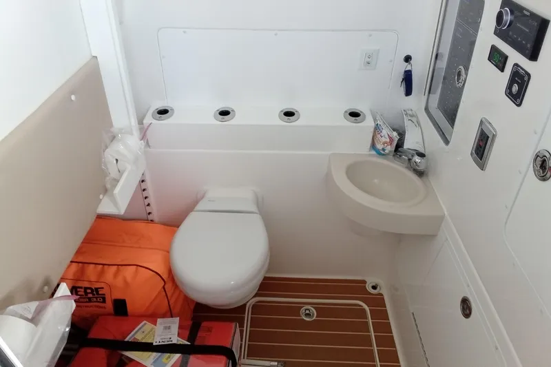 Slide: The Image of 2022 Invincible 39 Open Fisherman boat bathroom with toilet, sink, and safety equipment. - 30