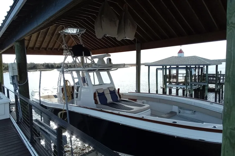 Slide: The Image of 2022 Invincible 39 Open Fisherman boat docked under a wooden shelter. - 51