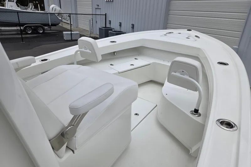 Slide: The Image of 2026 Pair Customs 24 Center Console MV boat interior with white seating and storage compartments. - 16