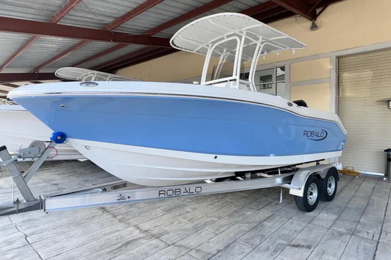 The Image of 2026 Robalo R202 Explorer boat on trailer in covered storage area. - 0