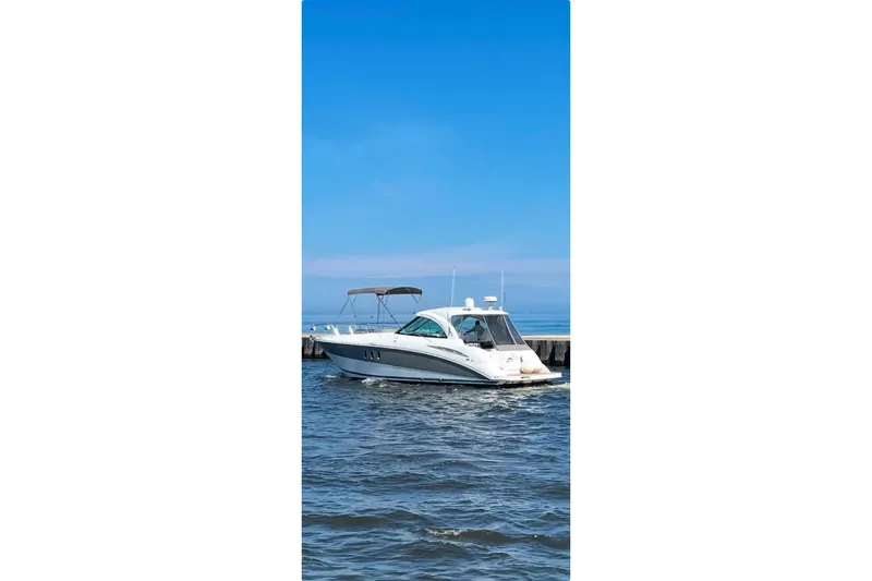 Slide: The Image of 2008 Cruisers Yachts 390 Sports Coupe on calm water under clear blue sky. - 4