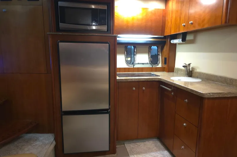 Slide: The Image of 2008 Cruisers Yachts 390 Sports Coupe kitchen with wood cabinets and stainless steel appliances. - 34
