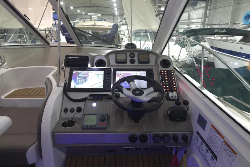 Slide: The Image of 2008 Cruisers Yachts 390 Sports Coupe helm with navigation screens and controls in a marina setting. - 45