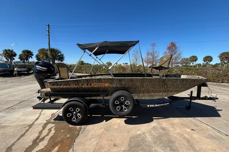 The Image of 2026 Tracker Grizzly 1756 T Marsh boat on trailer, camo design, with Mercury engine. - 0