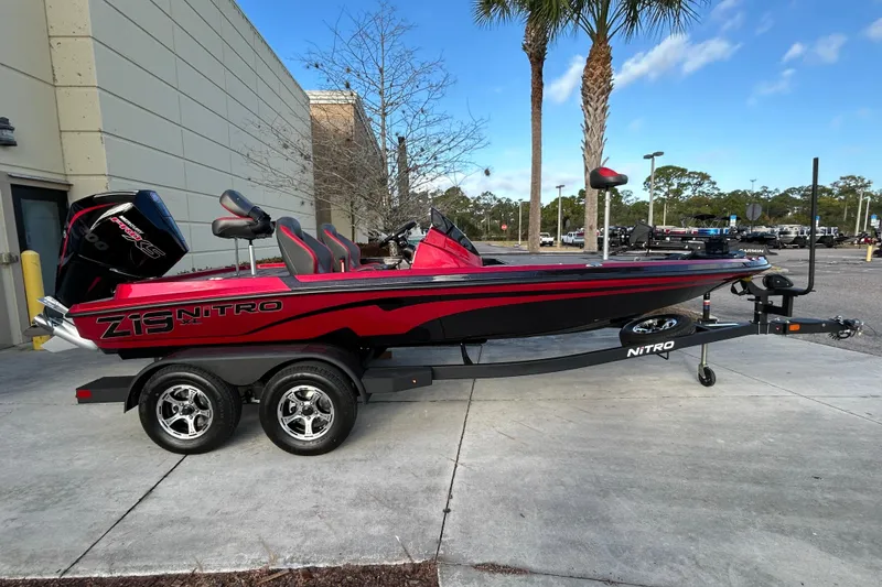 The Image of 2026 Nitro Z19 XL Pro boat on trailer, red and black design, parked outdoors. - 0