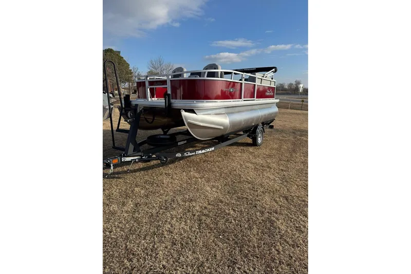 Slide: The Image of 2026 Sun Tracker Bass Buggy 16 XL Select pontoon boat on trailer, parked on grass. - 81