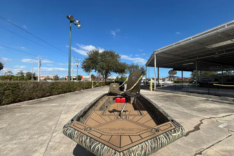 Slide: The Image of 2026 Tracker Grizzly 1650 T Prairie Wings Edition boat on display under clear blue sky. - 32