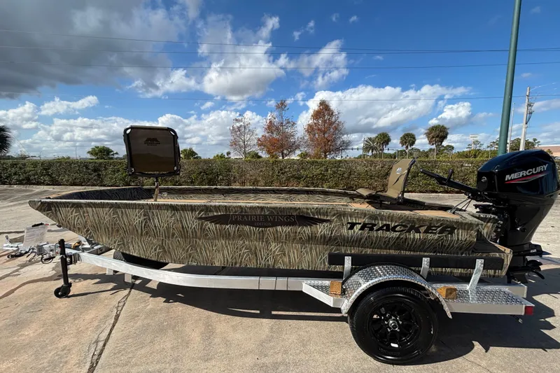 Slide: The Image of 2026 Tracker Grizzly 1650 T Prairie Wings Edition boat on trailer, camo design, outdoors. - 33