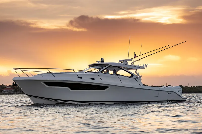 Slide: The Image of 2026 Pursuit OS 405 Offshore yacht at sunset on the water. - 13