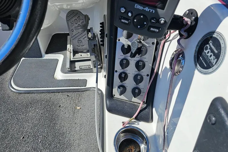 Slide: The Image of Control panel of a 2011 Phoenix 618 Pro boat with steering wheel and foot pedal. - 10