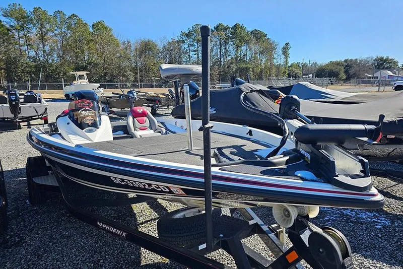Slide: The Image of 2011 Phoenix 618 Pro boat on trailer, parked outdoors, surrounded by other boats. - 5