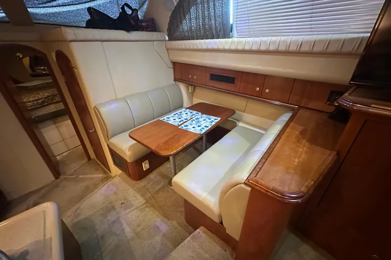 Slide: The Image of 2005 Cruisers Yachts 375 Motoryacht interior with cozy dining area and wooden cabinetry. - 6
