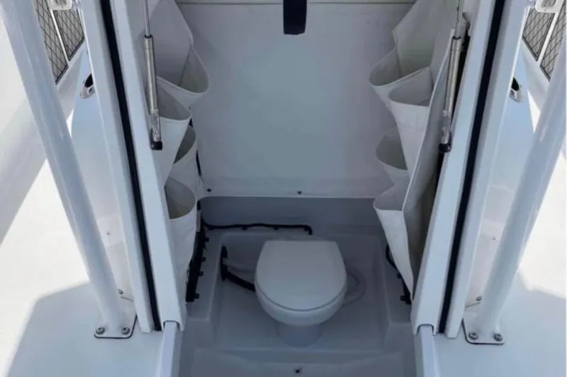 Slide: The Image of 2020 Wellcraft 220 Fisherman boat interior with compact marine toilet and storage compartments. - 5