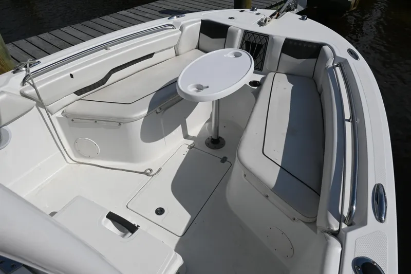 Slide: The Image of 2020 Wellcraft 222 Fisherman boat interior with seating and table, docked by water. - 13