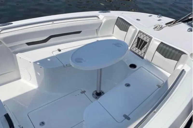 Slide: The Image of 2020 Wellcraft 220 Fisherman boat interior with seating and table on calm water. - 14