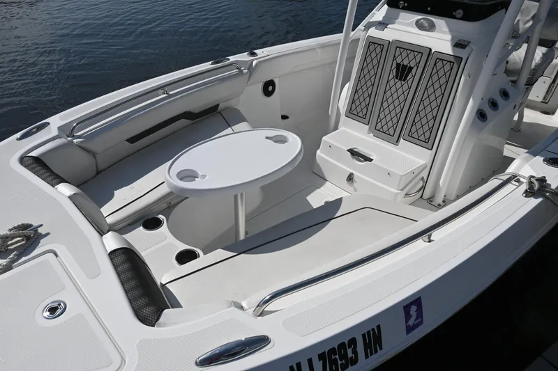 Slide: The Image of 2020 Wellcraft 222 Fisherman boat interior with seating and table on water. - 15