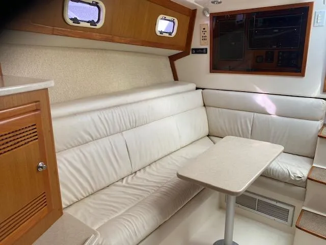Slide: The Image of Interior of 2000 Cabo 35 Express with white leather seating and wooden cabinetry. - 17