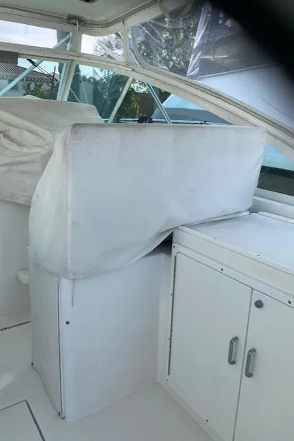 Slide: The Image of 2000 Cabo 35 Express boat interior with covered seating and storage cabinets. - 27