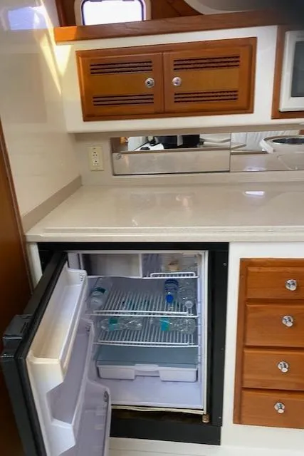 Slide: The Image of 2000 Cabo 35 Express yacht kitchen with open fridge and wooden cabinets. - 31