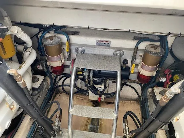 Slide: The Image of Engine room of a 2000 Cabo 35 Express boat with visible fuel filters and ladder. - 45