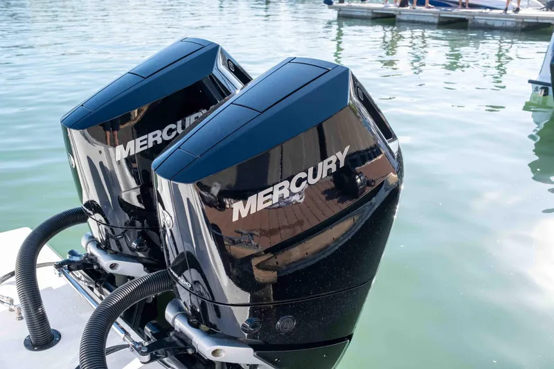 Slide: The Image of Twin Mercury outboard engines on a 2026 Reef Runner 340 boat, docked on calm water. - 4
