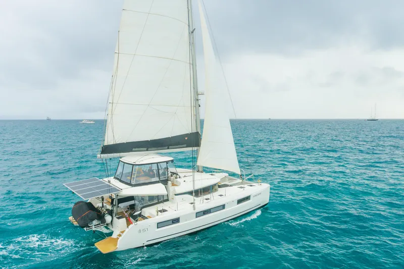 The Image of 2024 Lagoon 51 sailing yacht on open sea with solar panels. - 0