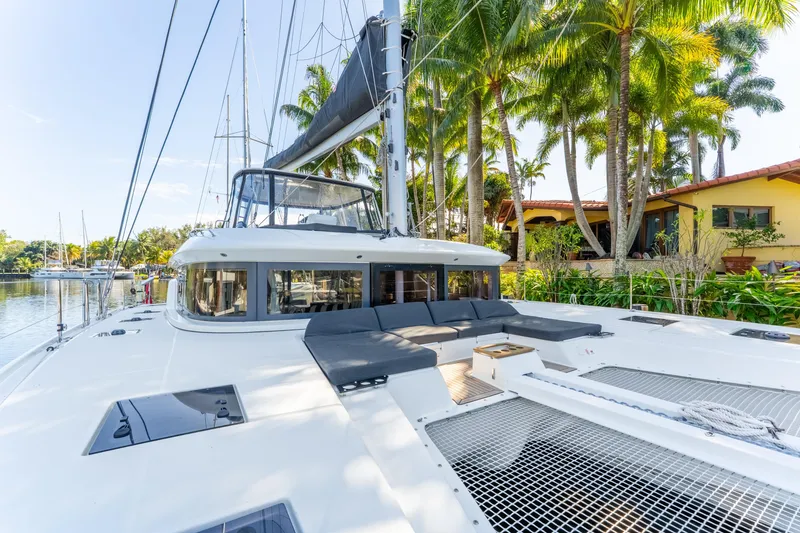 Slide: The Image of 2024 Lagoon 51 catamaran docked near tropical waterfront home. - 10