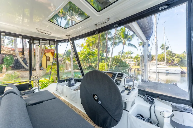 Slide: The Image of Interior view of 2024 Lagoon 51 yacht cockpit with tropical scenery outside. - 15