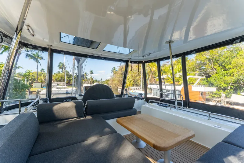 Slide: The Image of 2024 Lagoon 51 yacht interior with modern seating and panoramic windows. - 19