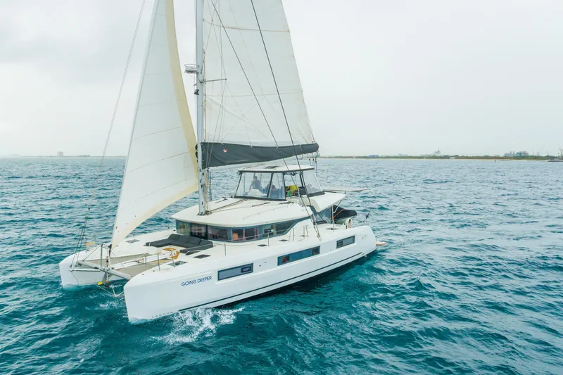 Slide: The Image of 2024 Lagoon 51 sailing catamaran navigating open sea under cloudy skies. - 2