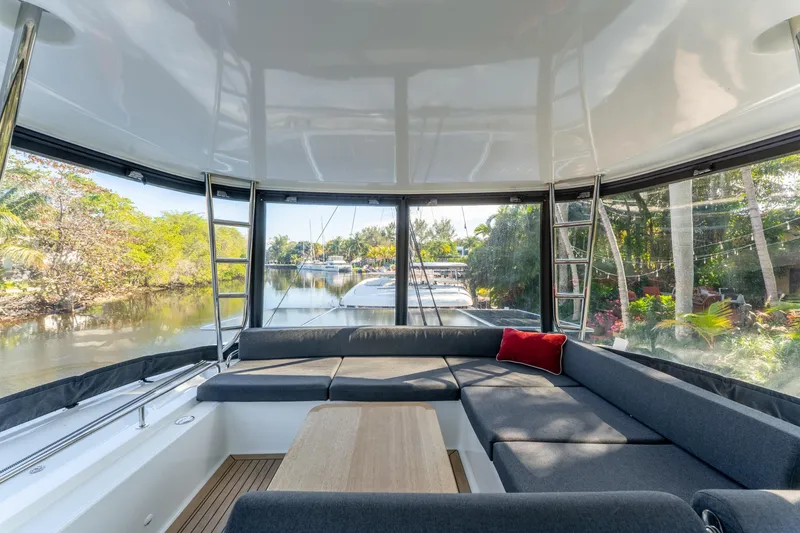 Slide: The Image of Interior view of 2024 Lagoon 51 yacht with spacious seating and scenic waterway backdrop. - 20