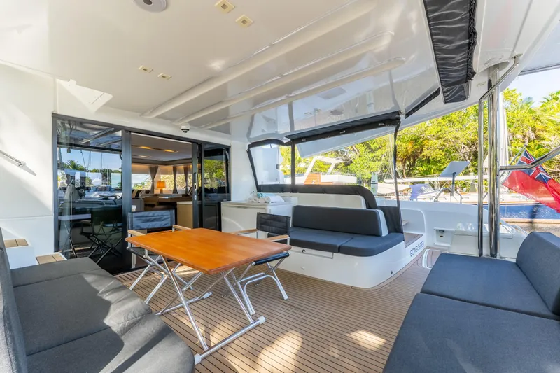 Slide: The Image of Spacious deck of 2024 Lagoon 51 yacht with modern seating and wooden table. - 21
