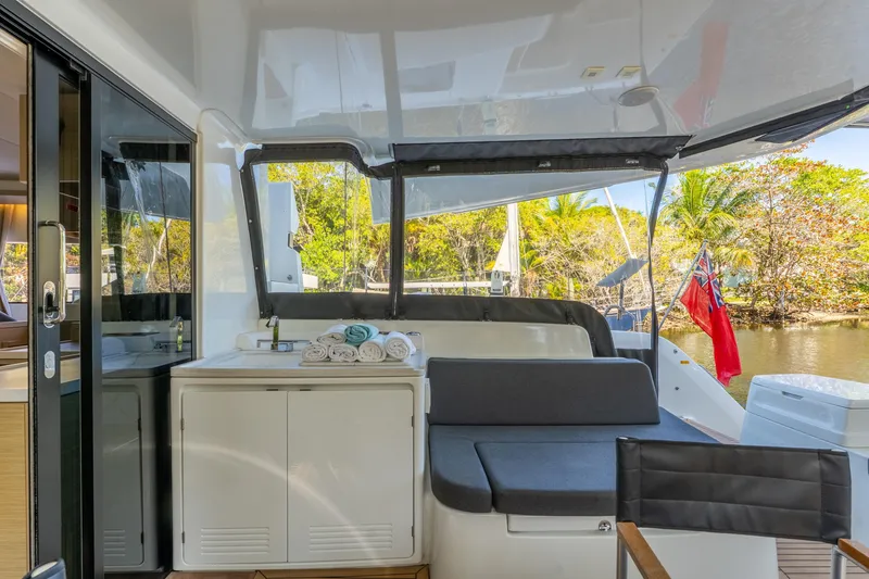 Slide: The Image of 2024 Lagoon 51 yacht interior with seating, towels, and scenic outdoor view. - 24