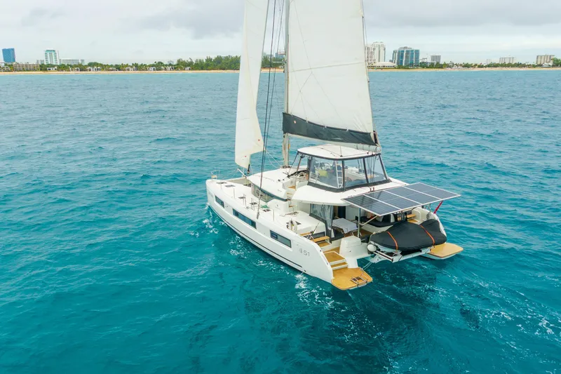 Slide: The Image of 2024 Lagoon 51 catamaran sailing on blue ocean near city skyline. - 3