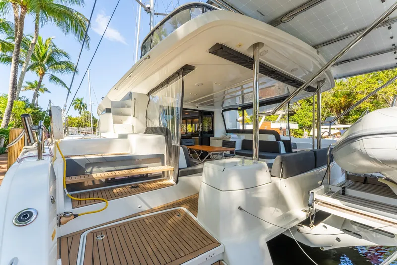 Slide: The Image of 2024 Lagoon 51 yacht deck with modern seating and tropical backdrop. - 32