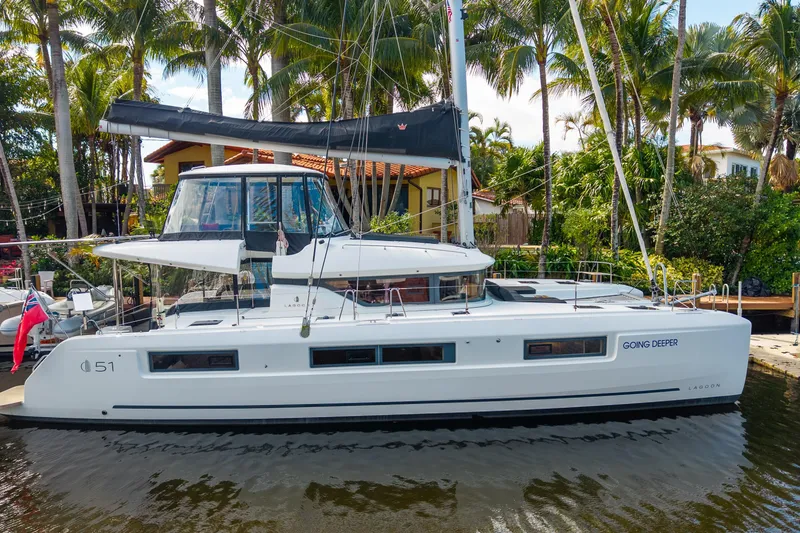 Slide: The Image of 2024 Lagoon 51 catamaran docked by palm trees, featuring sleek design and modern amenities. - 4
