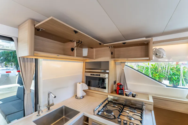 Slide: The Image of Modern kitchen interior of 2024 Lagoon 51 yacht with stove, sink, and open cabinets. - 40