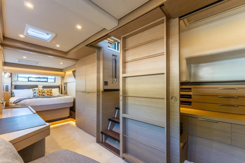 Slide: The Image of Luxurious interior of 2024 Lagoon 51 yacht featuring a cozy bedroom and modern wooden cabinetry. - 46