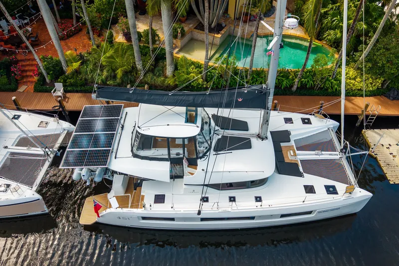 Slide: The Image of 2024 Lagoon 51 catamaran docked, featuring solar panels and luxurious design. - 6