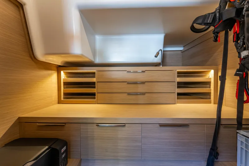 Slide: The Image of Modern interior of 2024 Lagoon 51 yacht with sleek wooden cabinetry and ambient lighting. - 60