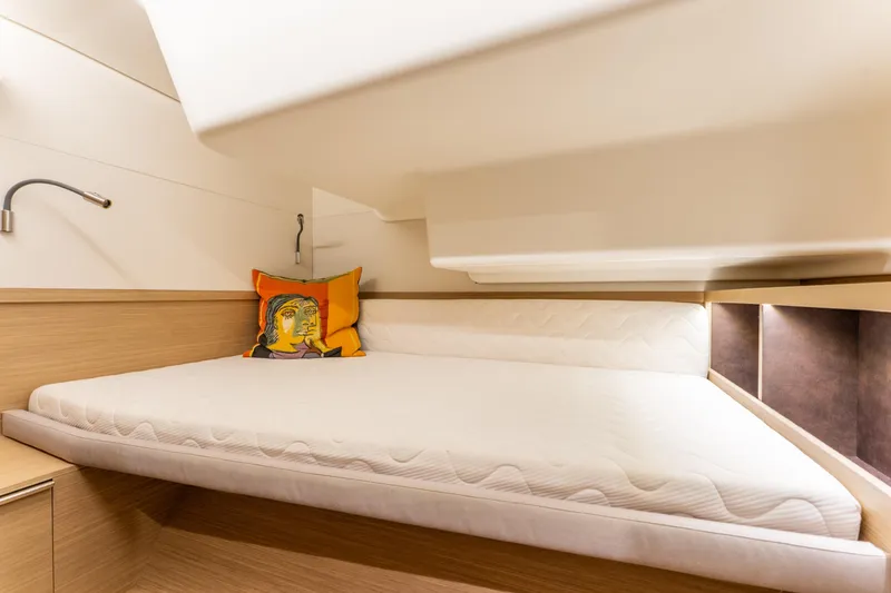 Slide: The Image of 2024 Lagoon 51 yacht cabin with modern design and colorful pillow. - 67