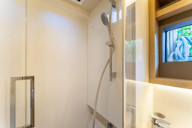 Slide: The Image of Modern shower area in 2024 Lagoon 51 yacht, featuring sleek design and window view. - 70